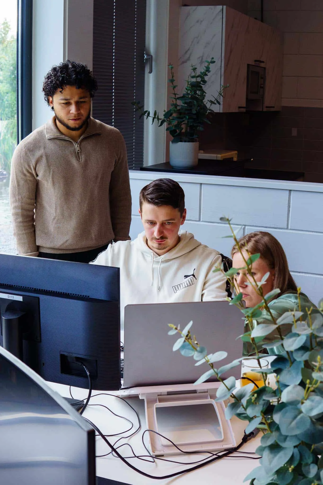 Developer overlegt met een collega achter de laptop
