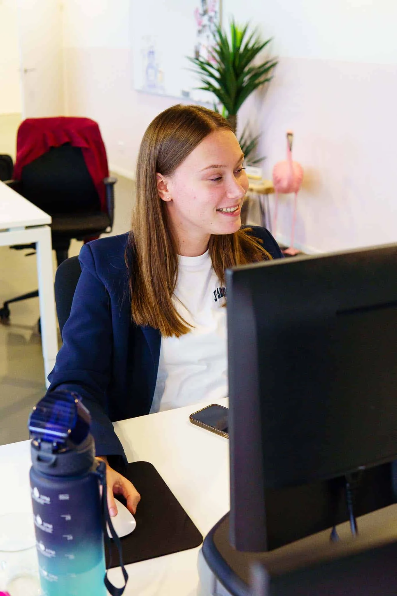 Collega lacht tijdens het werk achter haar computer