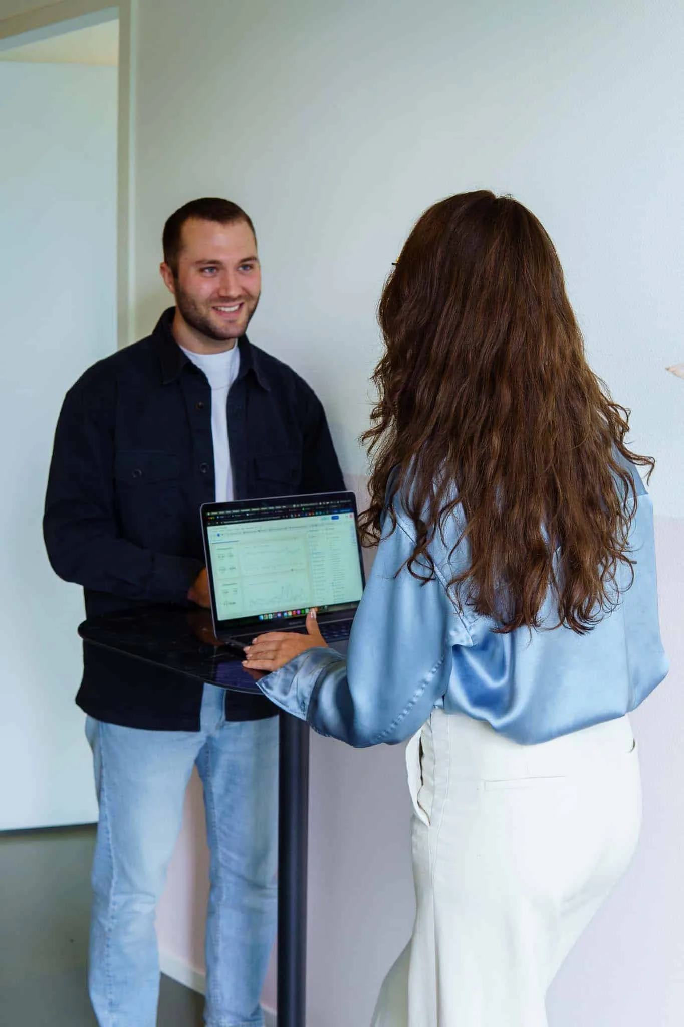 Collega laat de cijfers van een campagne zien op de laptop