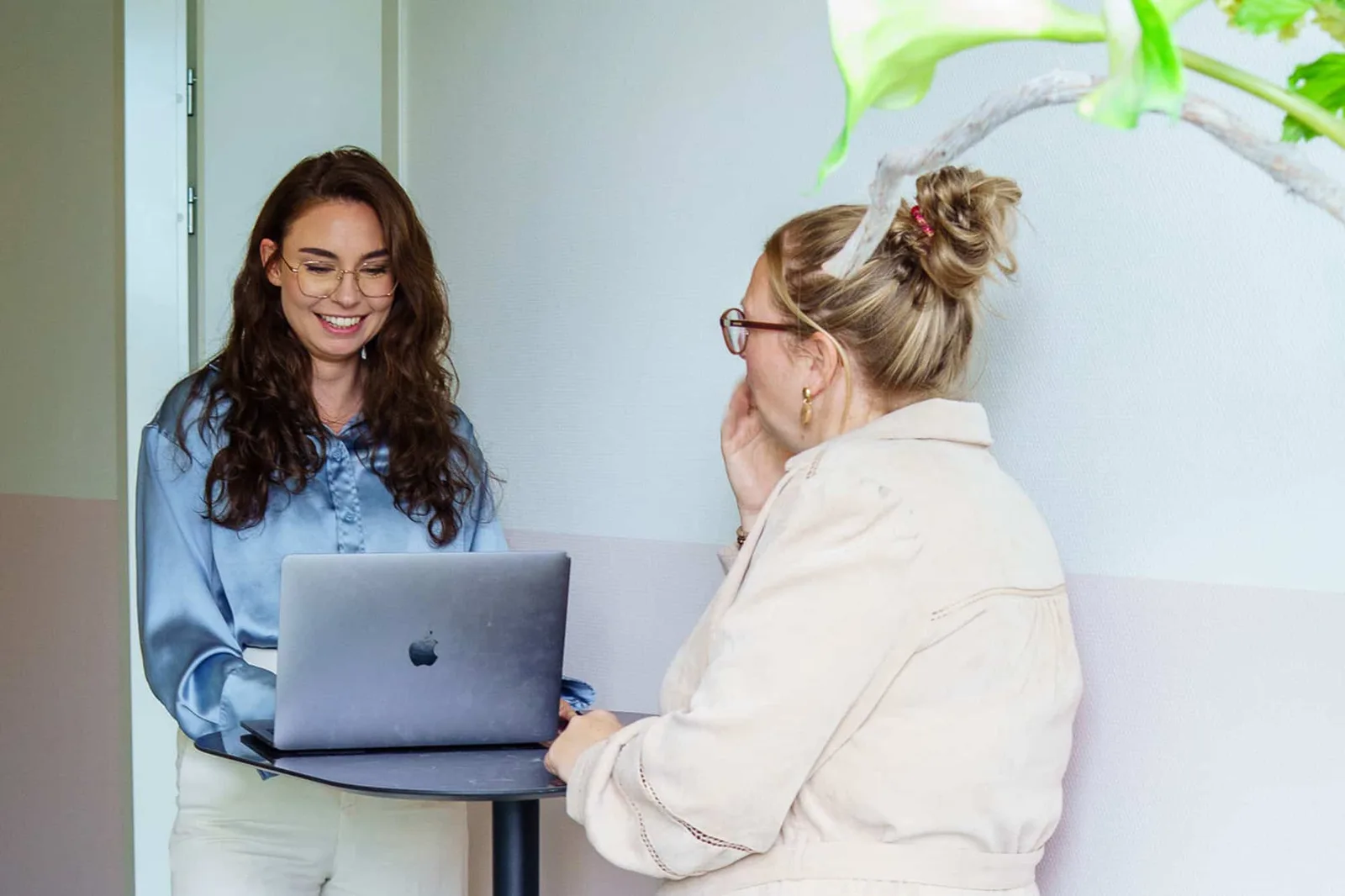 Twee collega’s kijken samen naar het werk op het scherm